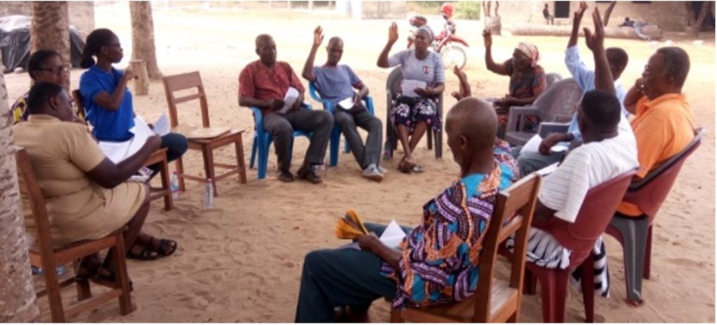 A group of people sitting in chairs outside.