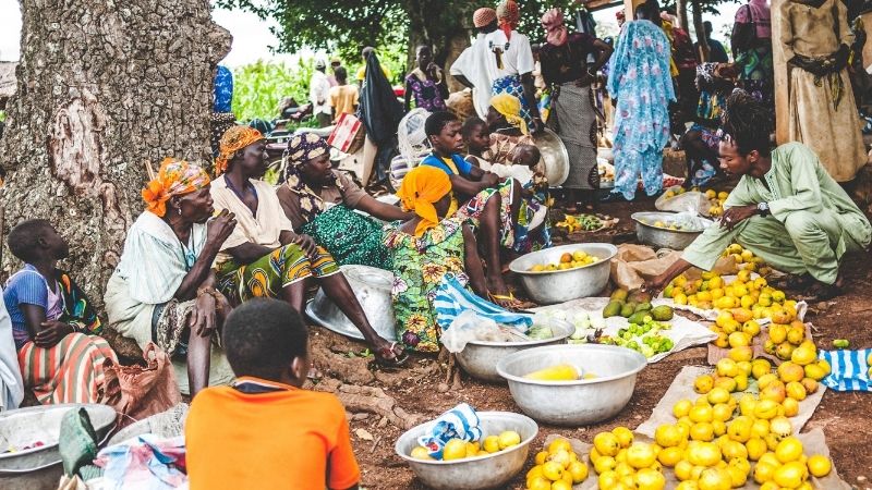 People sitting down and selling lemons.